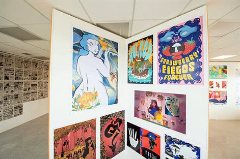 Artwork installation for graduation show featuring colourful prints and images with newspaper-based installation in background