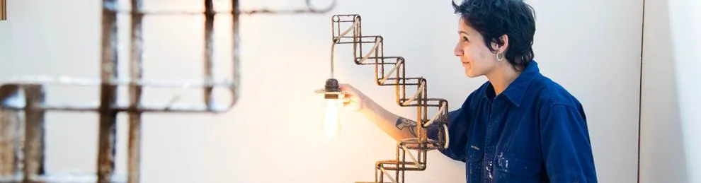 Student standing with 3D designed light fixture