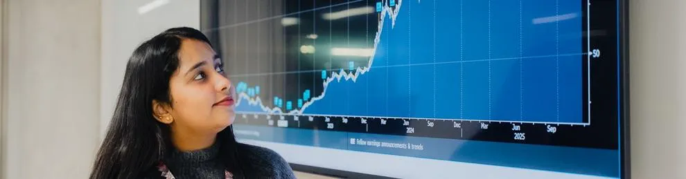 Student looking at a screen with a Bloomberg graph displayed