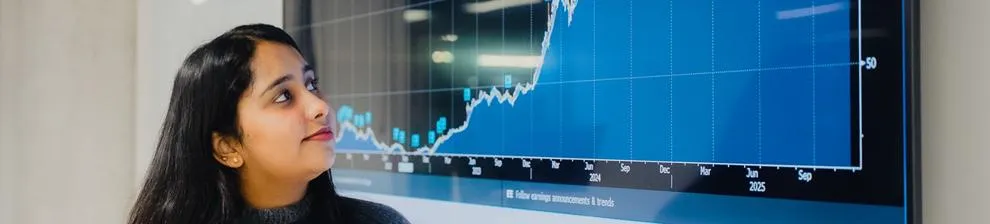 Student looking at a large digital data display in our Bloomberg Suite