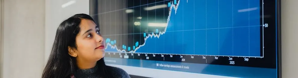 Young woman looking at monitor displaying a graph