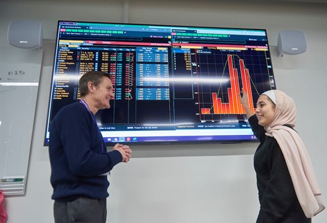 Lecturer and PG student looking at Bloomberg screen