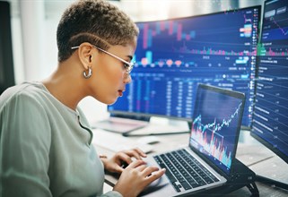 Student working on a laptop looking at investment graphs