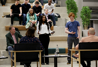 Students presenting to a panel in Elm House atrium