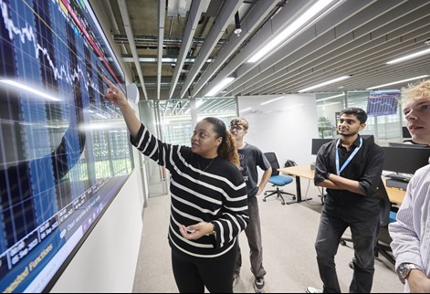 Students reviewing a screen of financial data