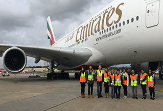 Students next to an Emirates jet