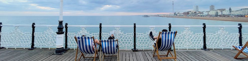People sitting in deckchairs on Brighton Pier