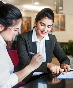 Two business women signing a contract