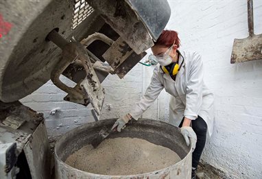 Student mixing concrete in a lab