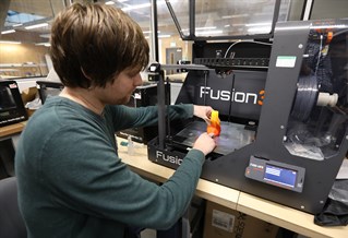Student using a 3D printer