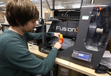 Student using an advanced 3D printer