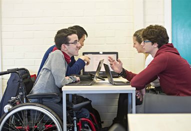 Student in wheelchair doing group project work analysing data