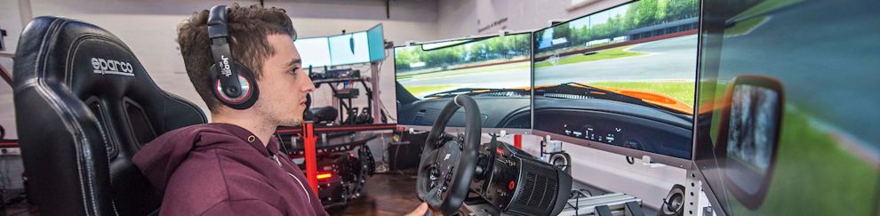 Engineering student on the driving simulator screens in view