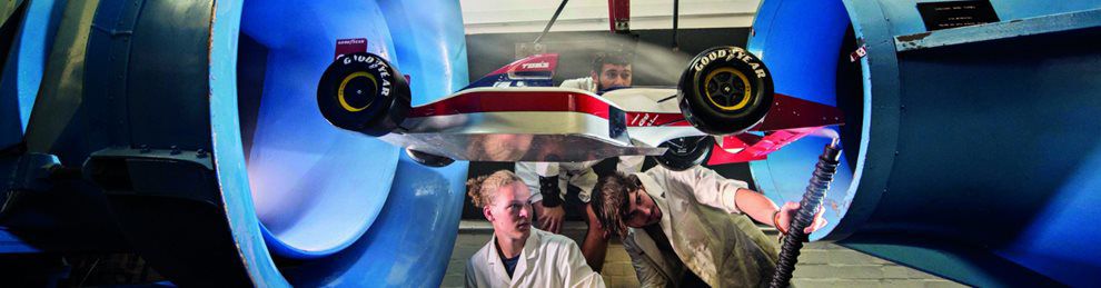 Engineering students testing a model of a sports car in a windtunnel