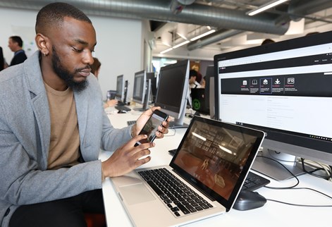 Male student working on app in front of computer