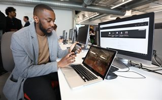 Male student developing software sitting in front of a computer