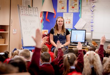 Children with their hands up to answer a question