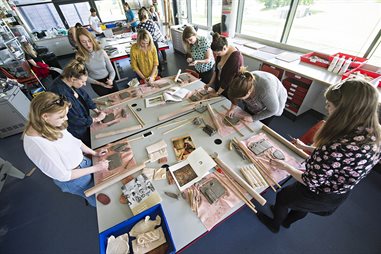 Students around a table working in clay