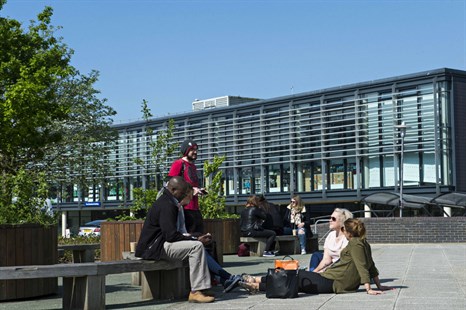 Group of students sitting outside on the Falmer campus