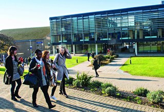 students walking outside Checkland building