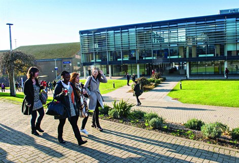 Students walking past the Checkland Building at Falmer