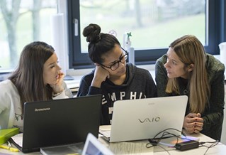 students and tutor on laptop