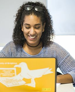 Head and shoulders of a student with her laptop in front of her
