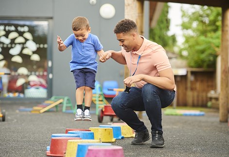 male teacher and child playing on stepping blocks