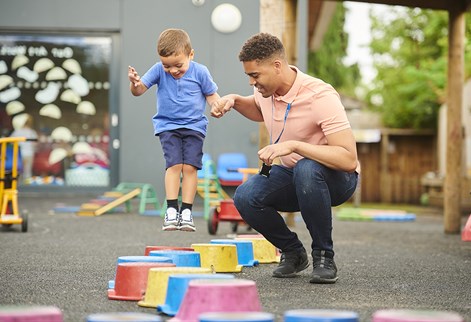 male teacher with child on stepping blocks