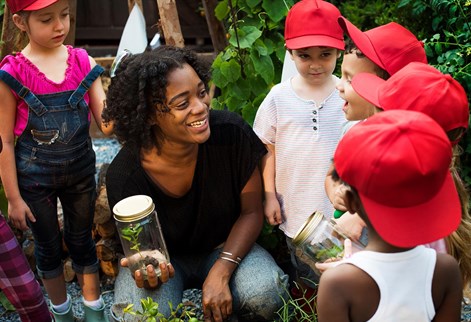 early years teacher showing plant to children
