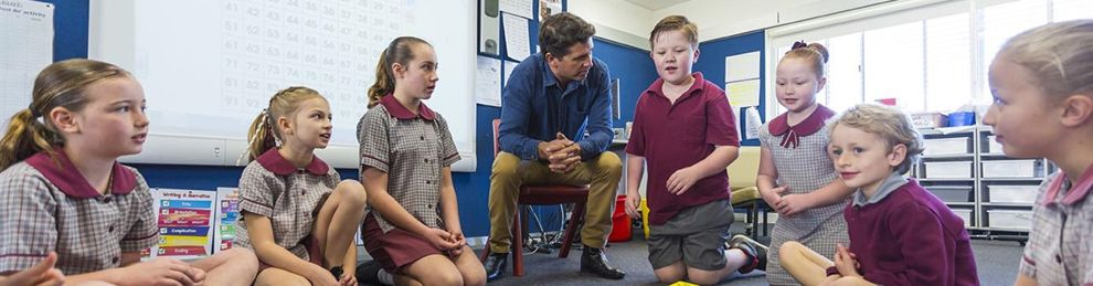 male teacher and children doing maths