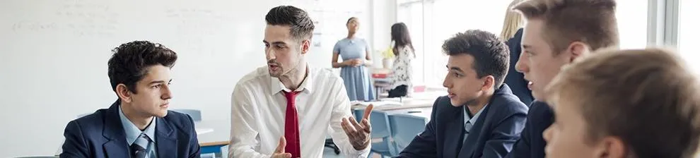 male teacher sitting with students