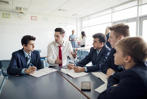 male teacher sitting with students