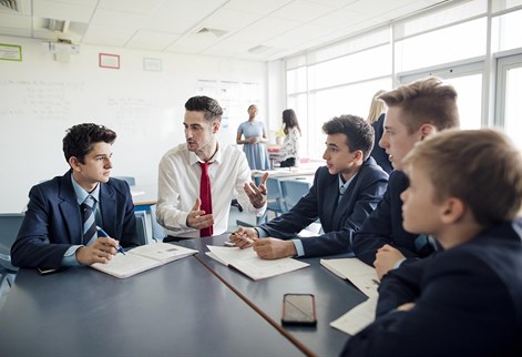 male teacher sitting with students