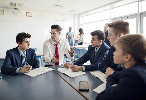 male teacher sitting with students