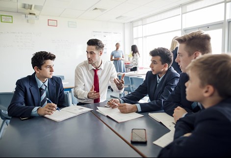 male teacher sitting with students