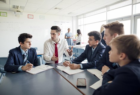 male teacher sitting with students