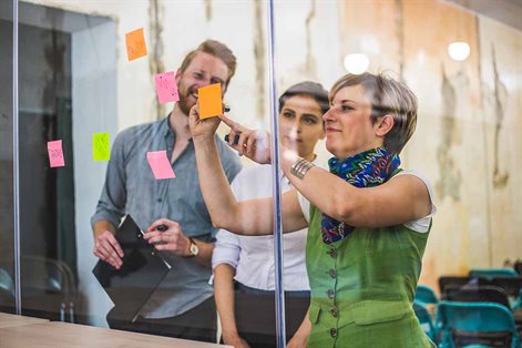 People putting post-it notes on a window