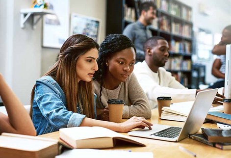 students round a laptop