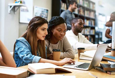 students round a laptop