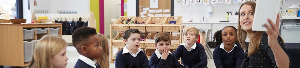 teacher and students cross legged on the carpet