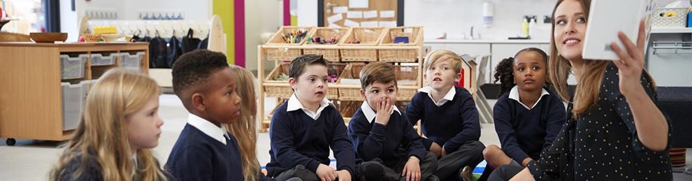 teacher and students cross legged on the carpet