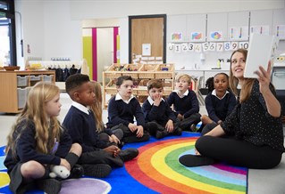 teacher and students cross legged on the carpet