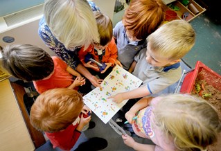 Nursery children pointing at a book