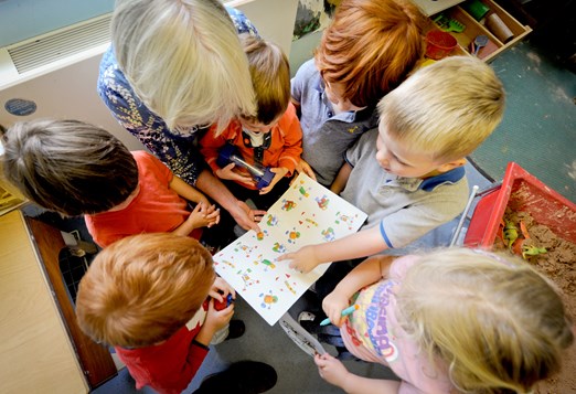 birds eye view of teacher reading to a group of nursery children