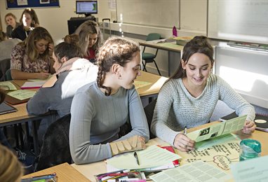 Two students having a discussion in a classroom