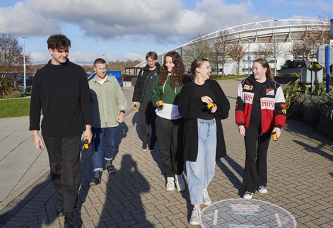 A group of students walking through Falmer campus