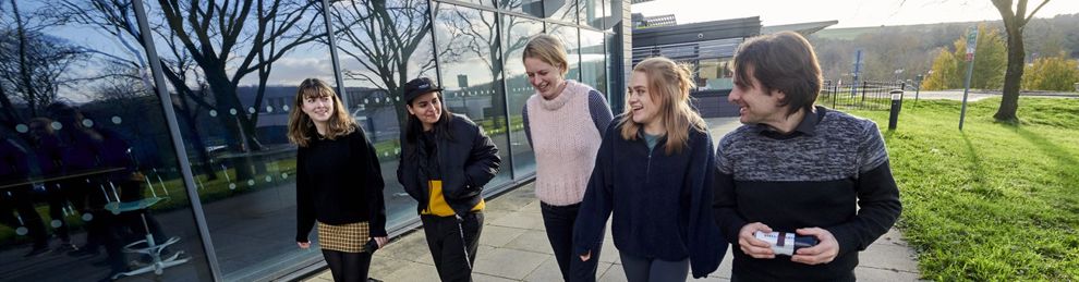 Group of students walking past Checkland Building