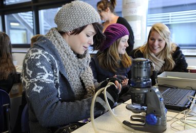 Students chatting around a microscope