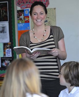 Student teacher reading to young pupils
